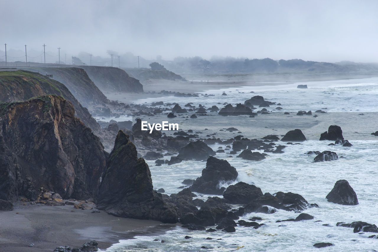 Rocks in sea against sky