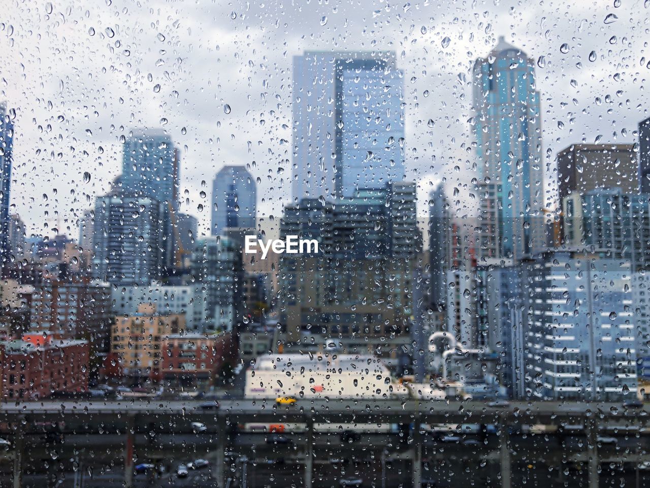 Cityscape seen through wet window during rainy season