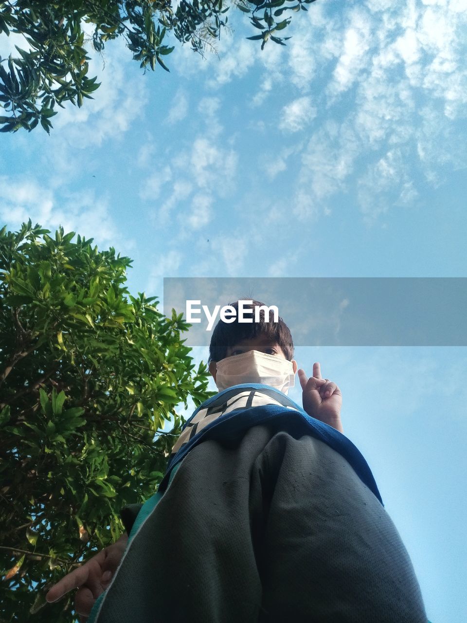 Low angle view of man against sky in pandemic