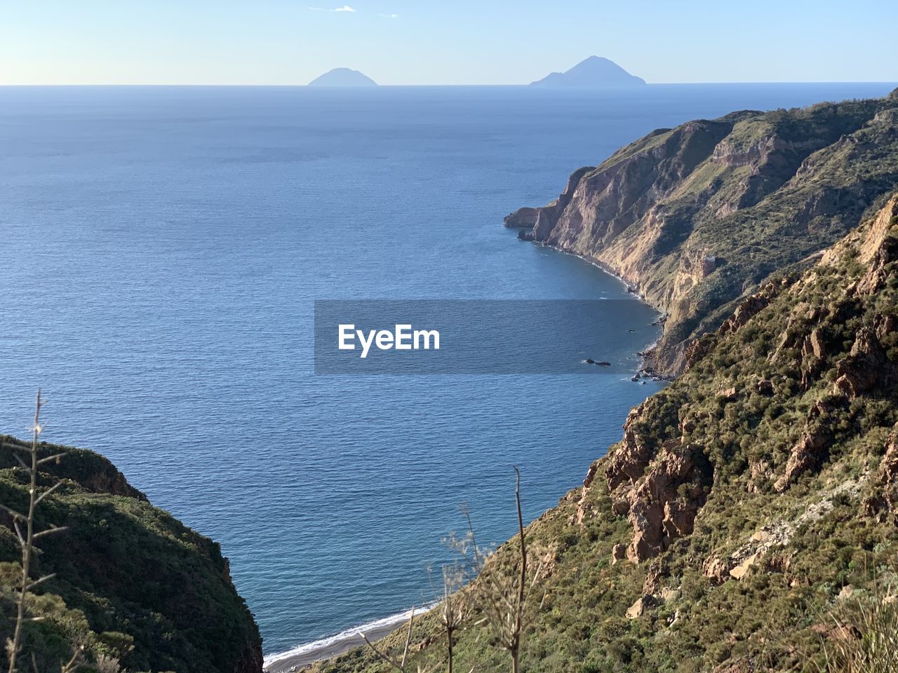 Scenic view of sea and mountains against sky