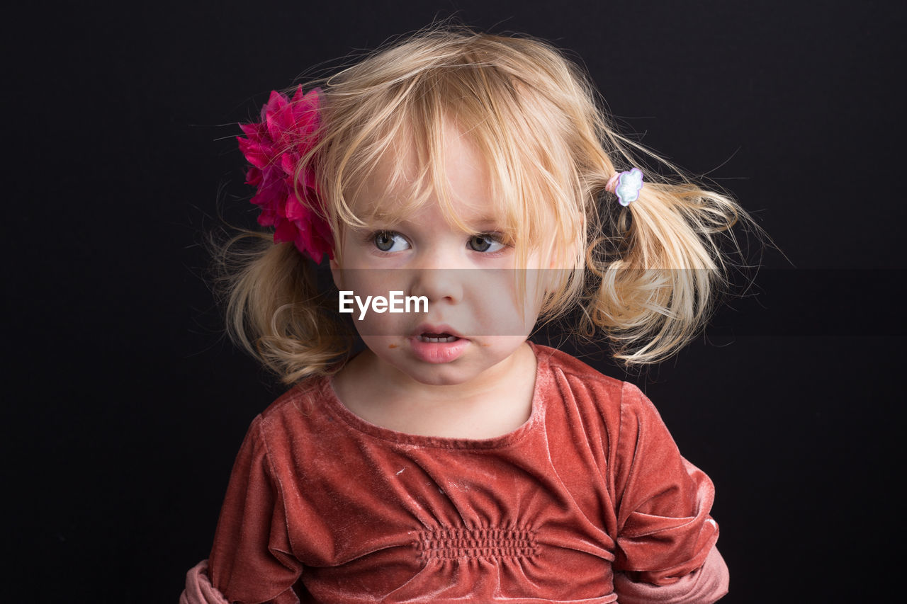 Cute innocent girl against black background