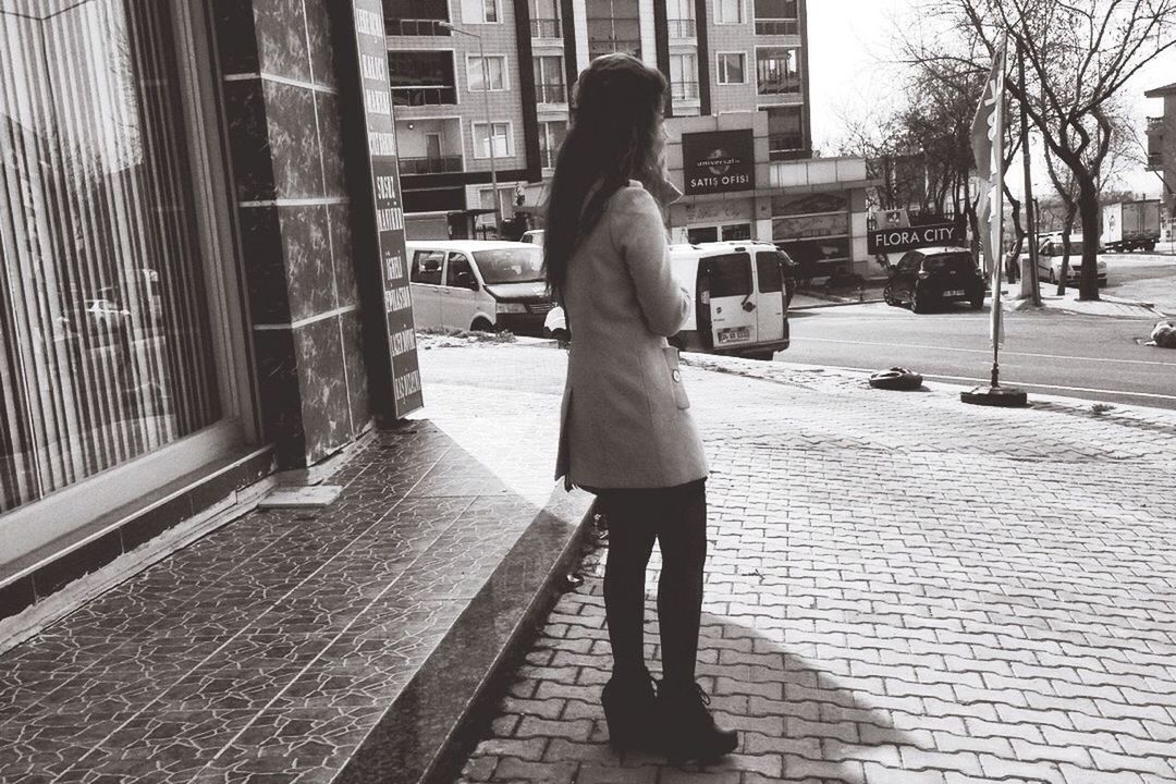 WOMAN STANDING ON CITY STREET