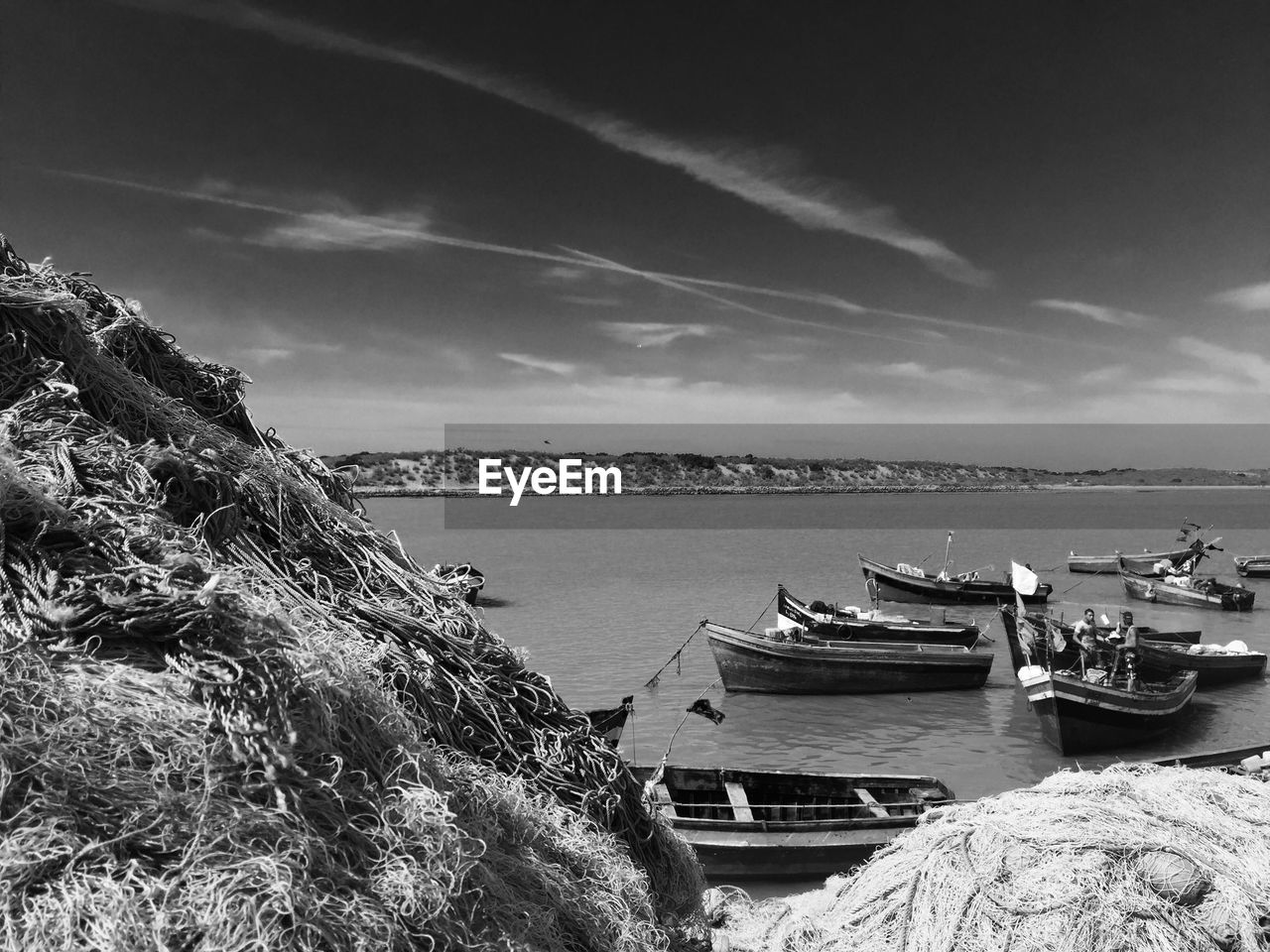 Fishing boats in river against sky