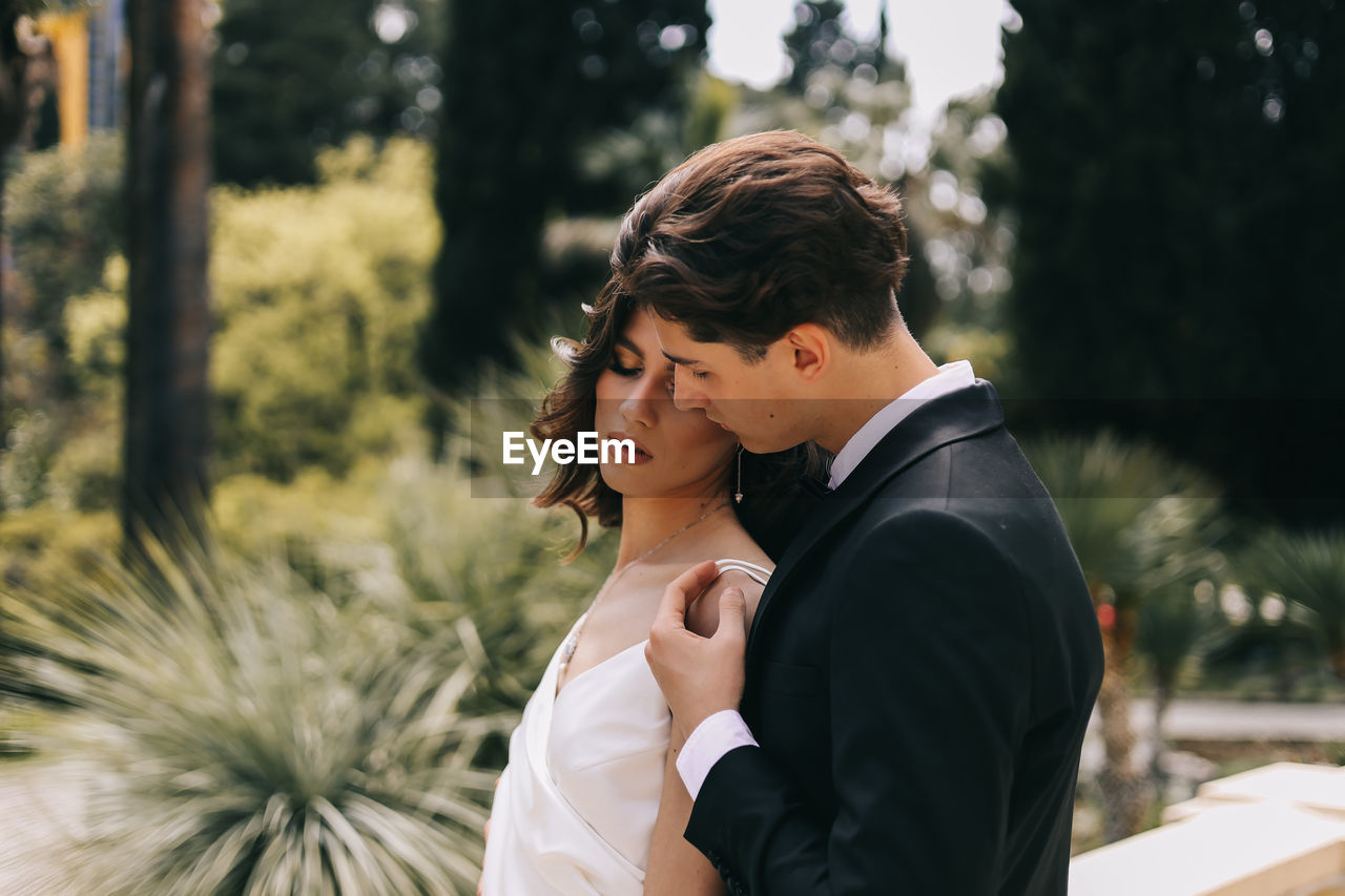 A beautiful couple in love, bride and groom in wedding clothes, walk and pose in the park in nature