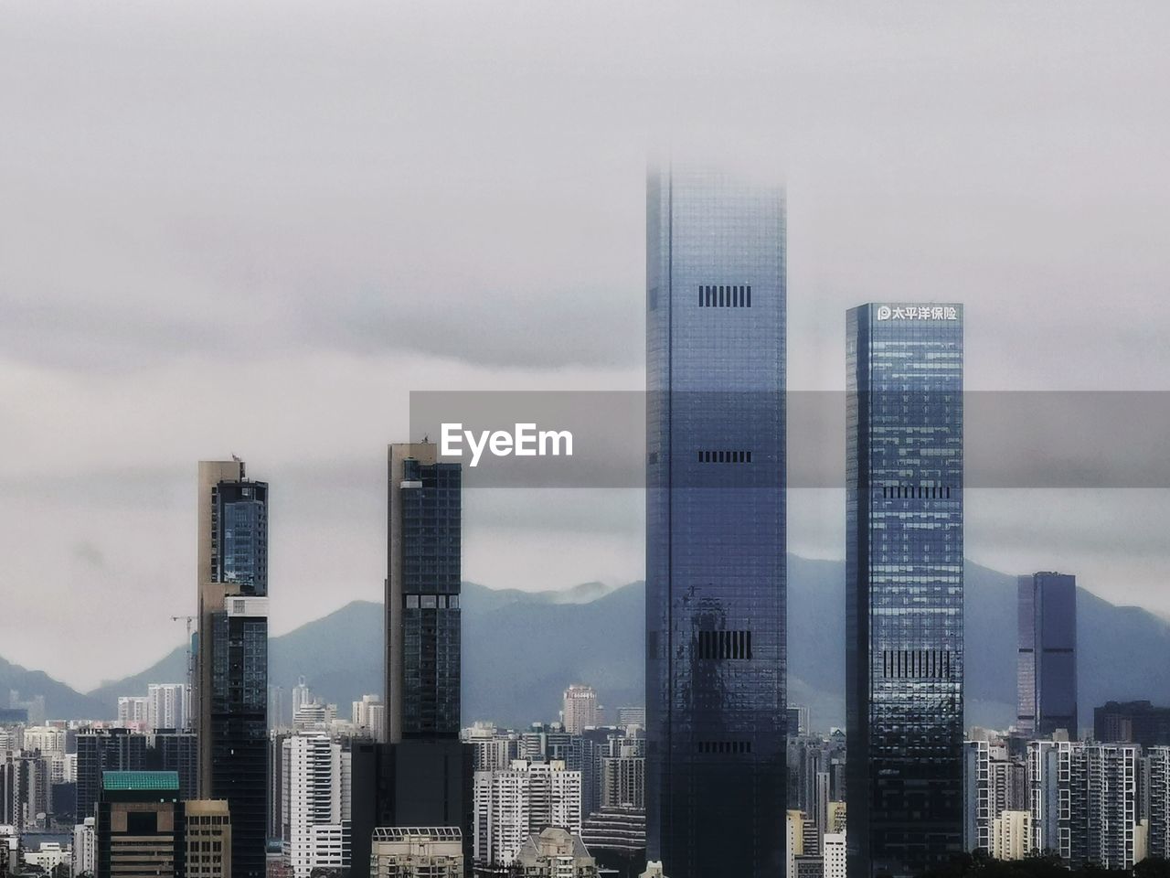 Buildings in city against cloudy sky