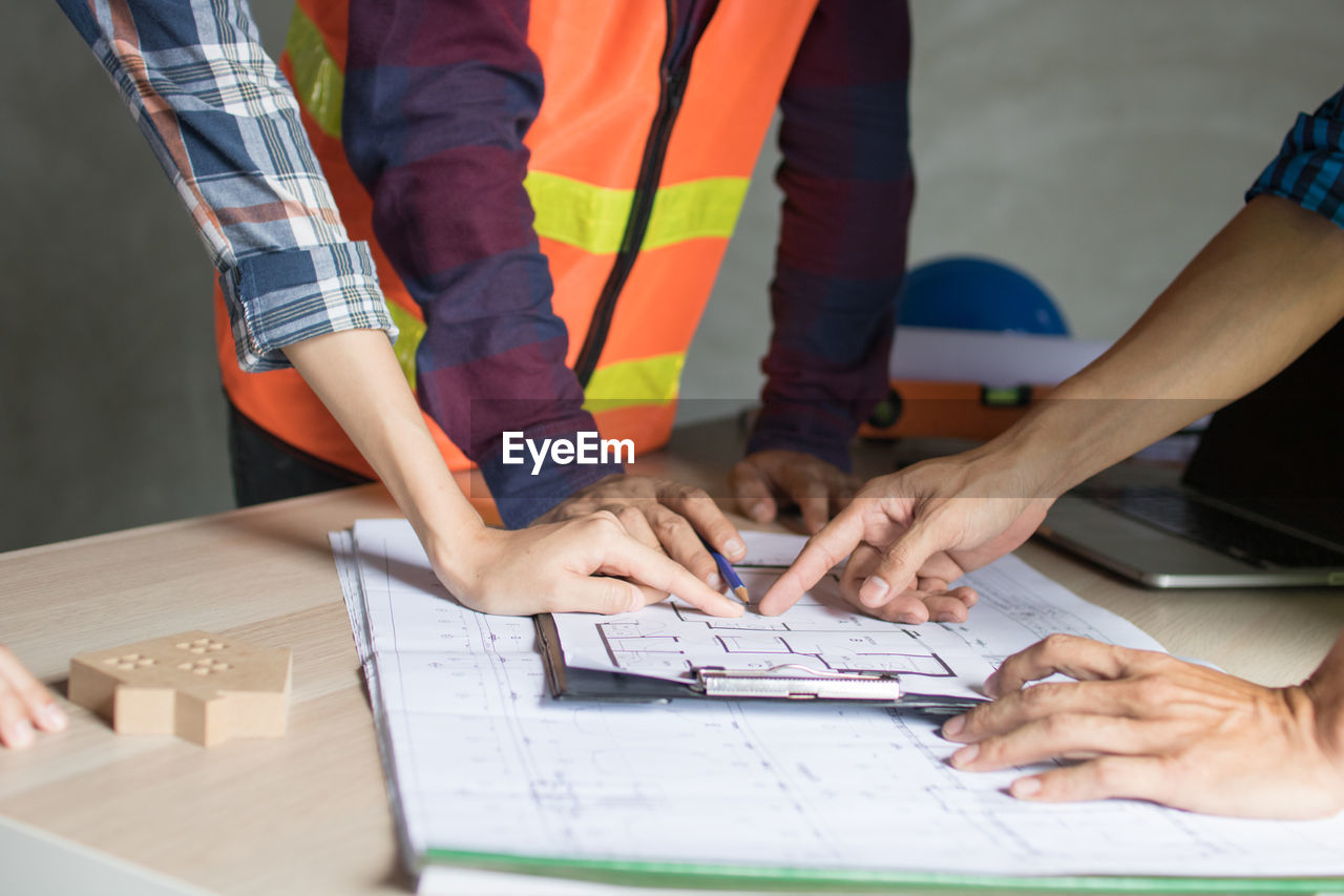 LOW ANGLE VIEW OF PEOPLE WORKING IN THE TABLE