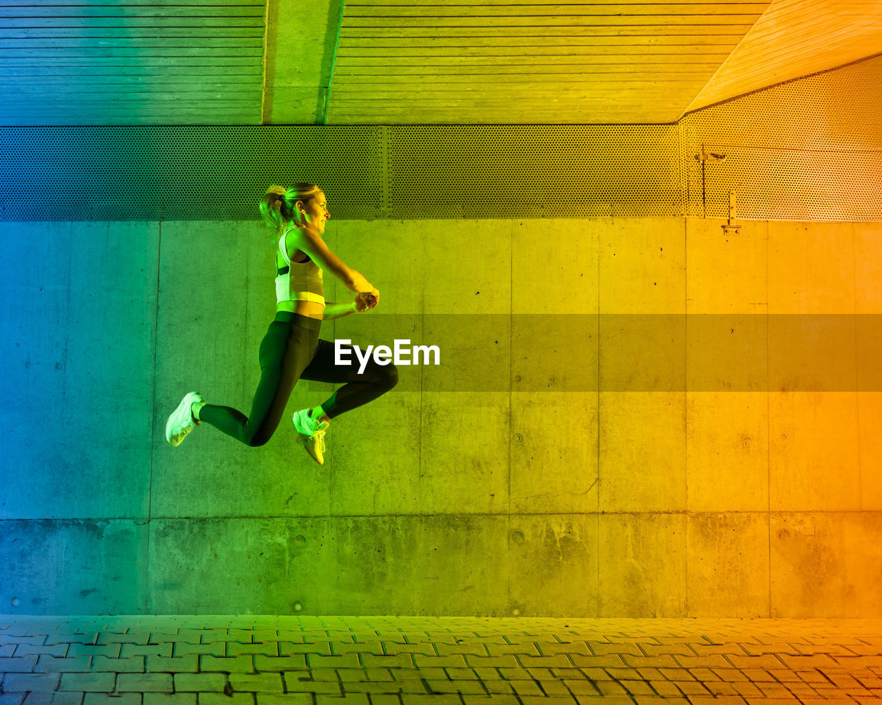 Woman jumping in front of wall