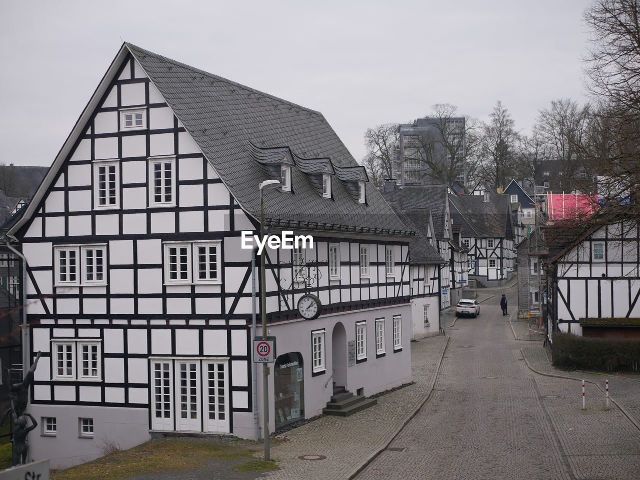 Street amidst houses and buildings against sky