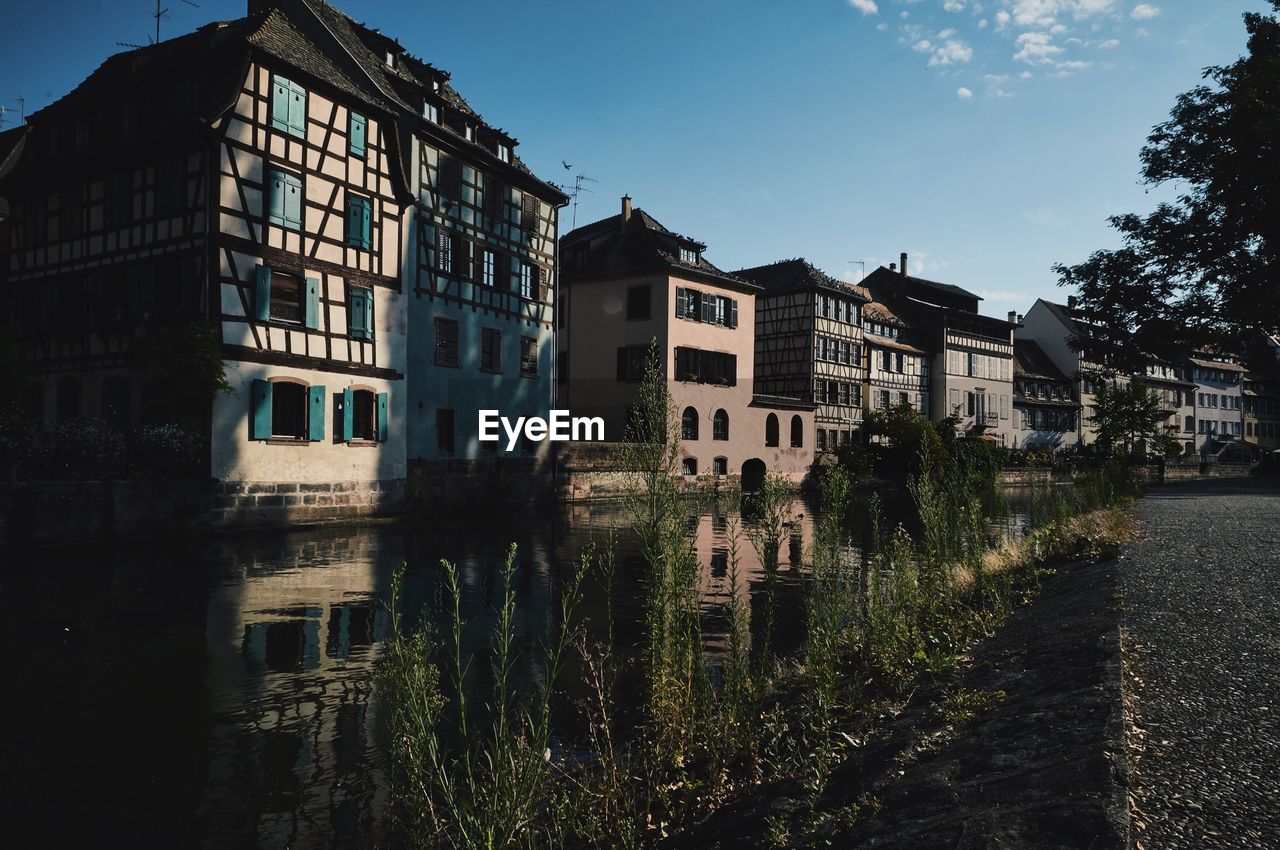 Buildings by lake against sky in city