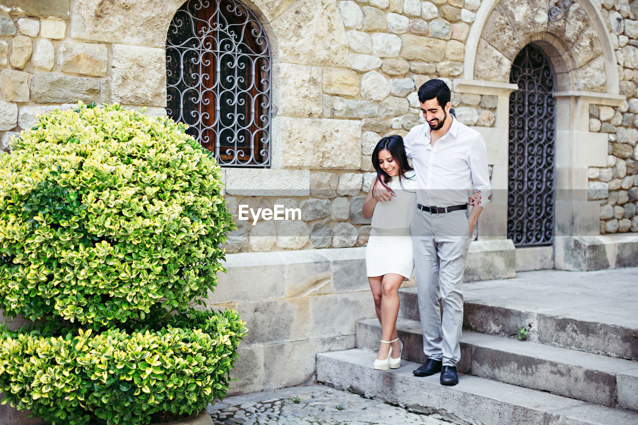 Full length of couple moving down on steps