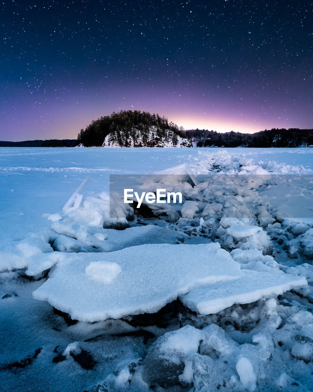 Scenic view of frozen lake in canada against sky at night