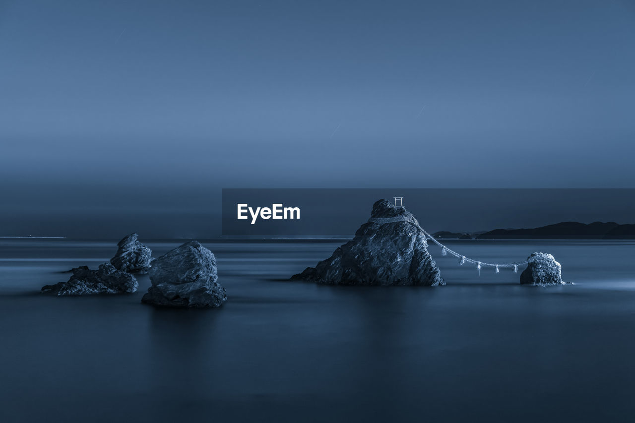 Scenic view of rocks in sea against sky