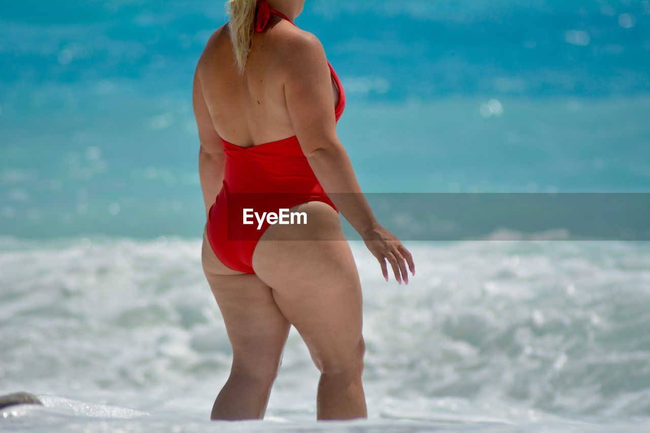 Midsection of woman standing in sea