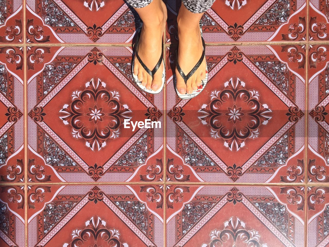 Low section of woman standing on tiled floor