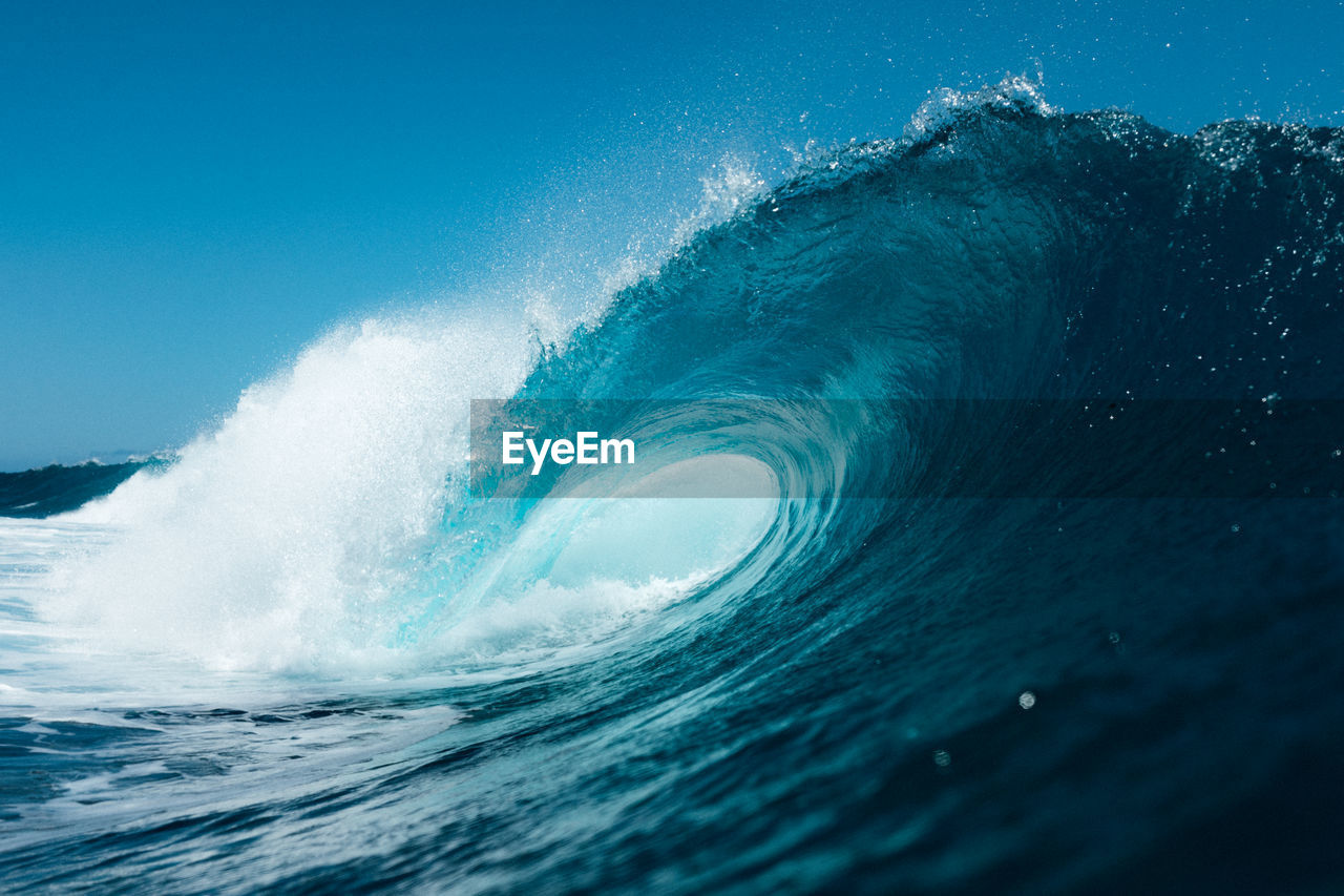 Blue wave breaking on the beach in summer