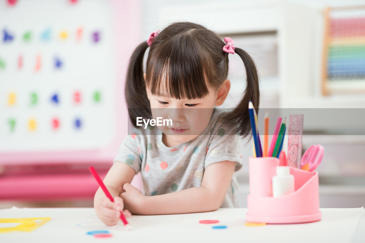 Young girl practice drawing different shapes for homeschooling