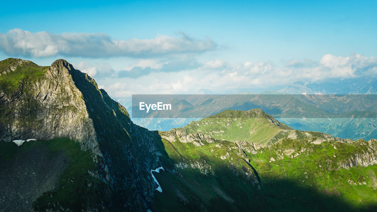 Rocks, passes and mountain peaks on the background of the blue sky with clouds. a mountain summer 