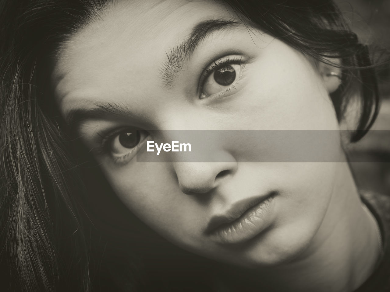 Close-up portrait of girl with raised eyebrows outdoors