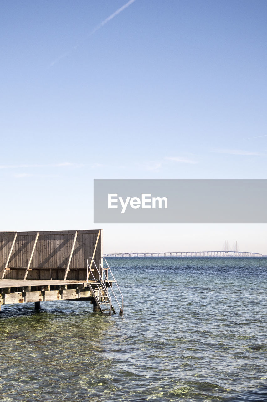 Jetty over sea against clear sky