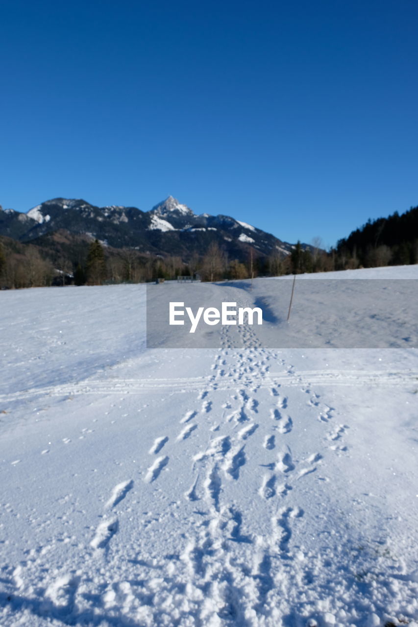 Scenic view of snowcapped mountains against clear blue sky