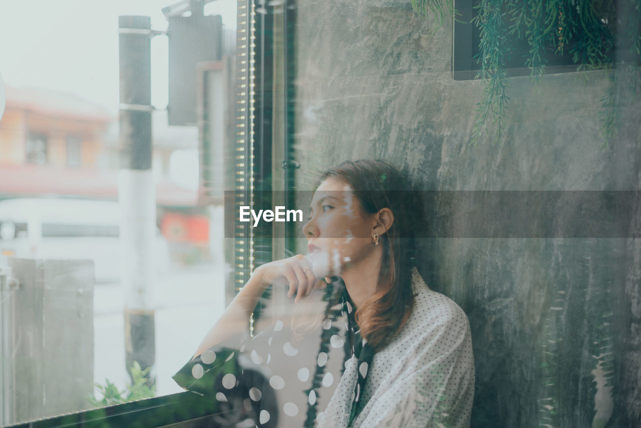 Woman sitting by window at home