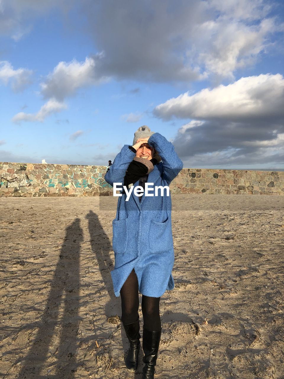 Smiling woman walking on land against sky