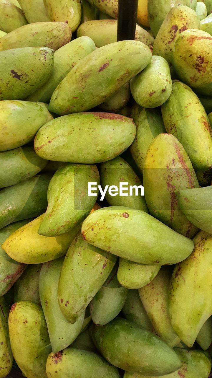 Full frame shot of raw mangoes for sale at market