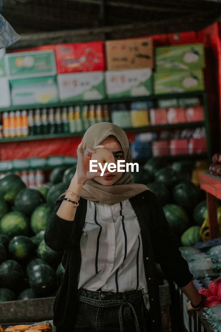 PORTRAIT OF MAN STANDING BY STORE