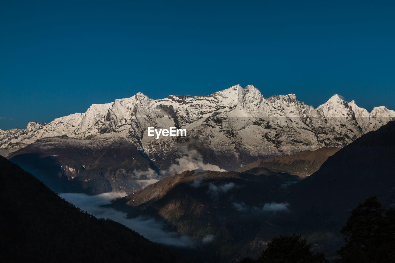 Scenic view of mountains against clear blue sky