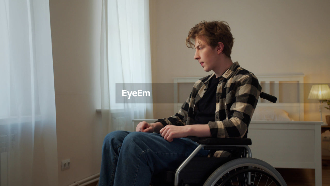 Full length of boy sitting at home