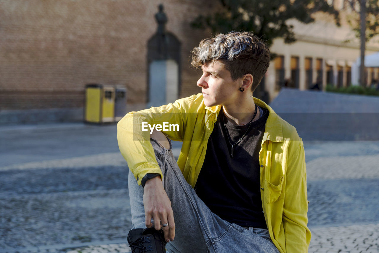 Portrait of a non binary person looking at camera while posing outdoors. person