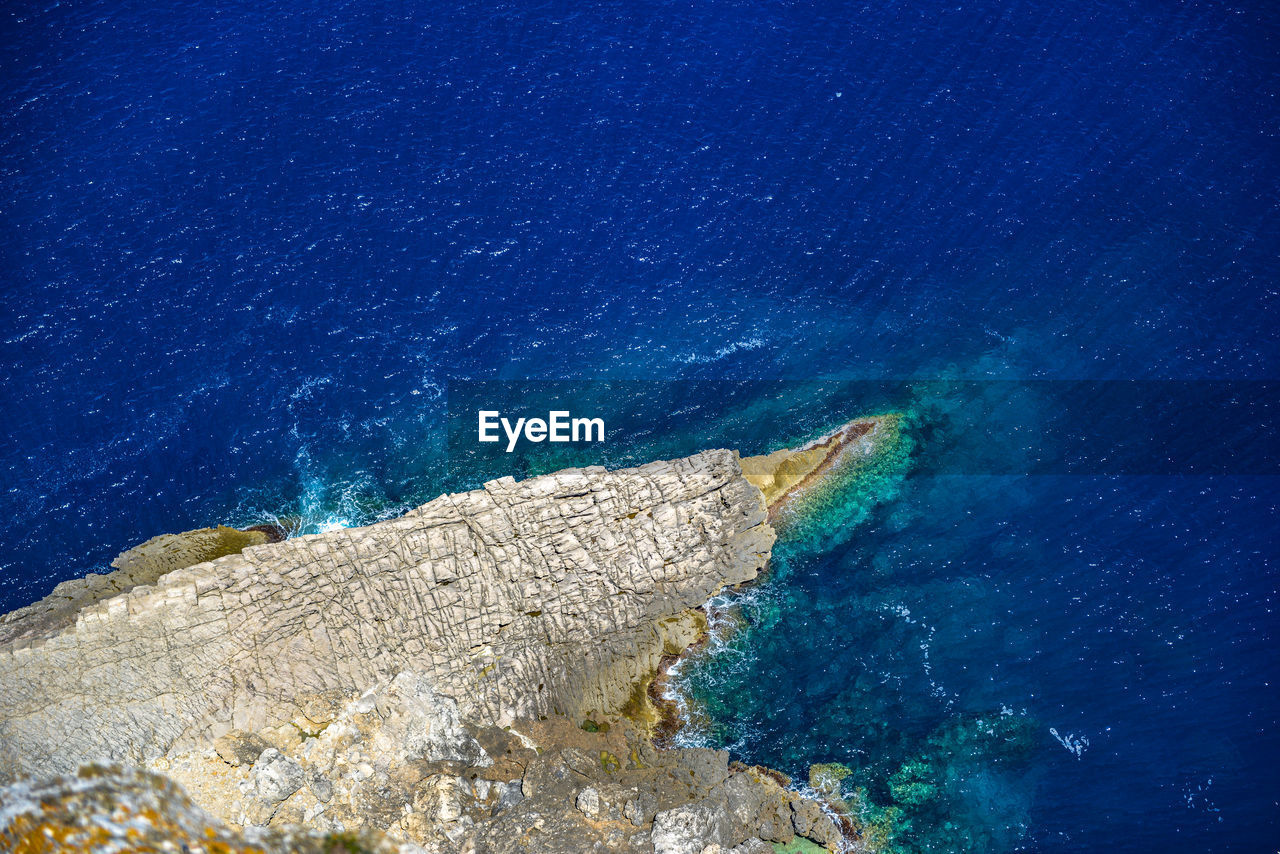 HIGH ANGLE VIEW OF BLUE SEA AND ROCK FORMATIONS
