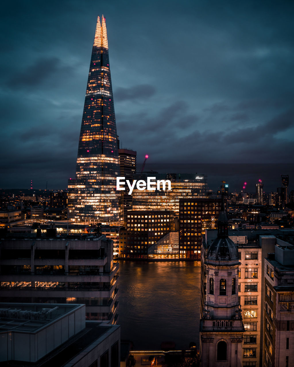 Illuminated cityscape against sky at night