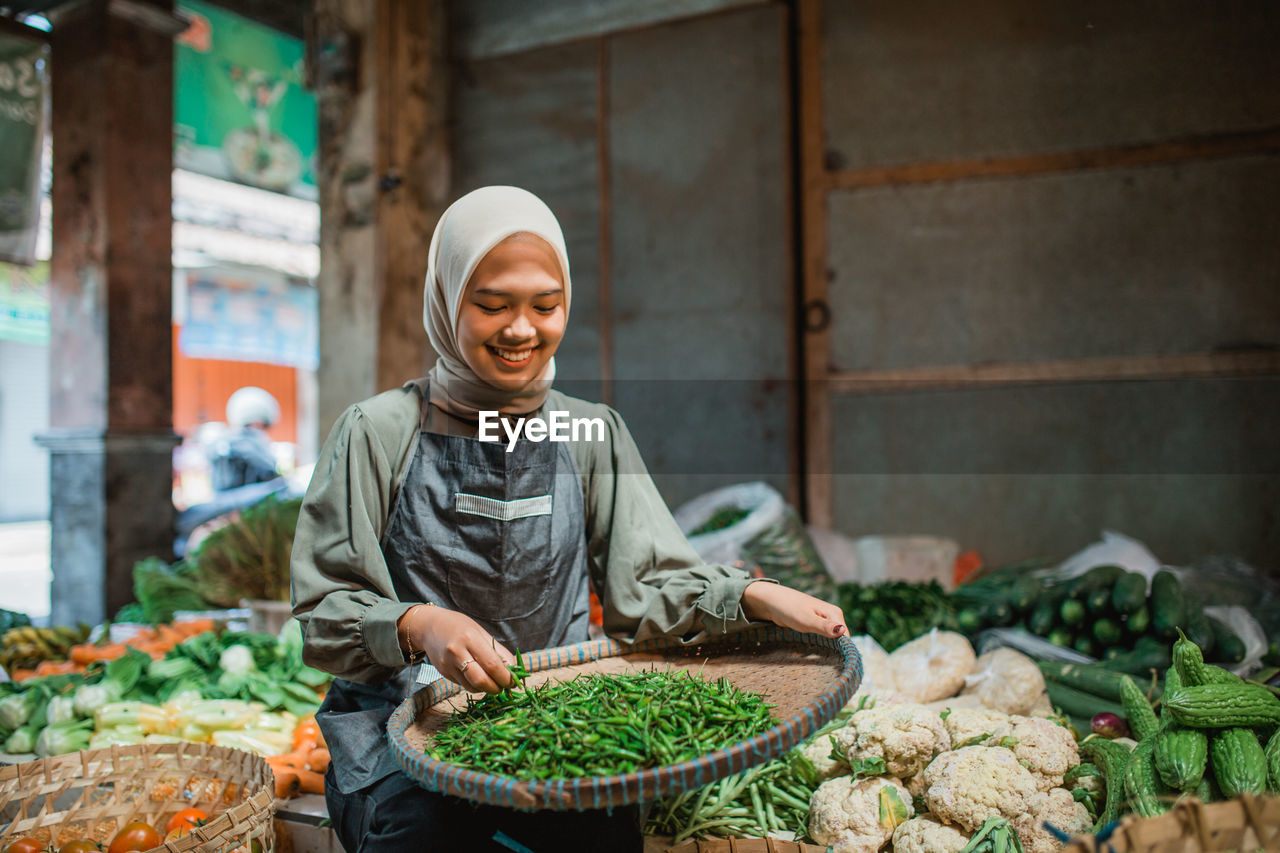 portrait of young man preparing food at market