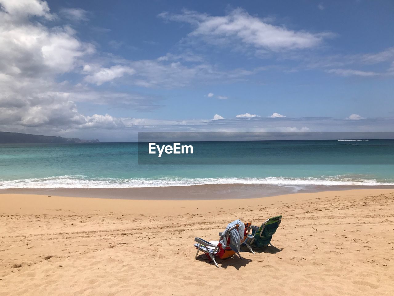 Scenic view of beach against sky on sunny day