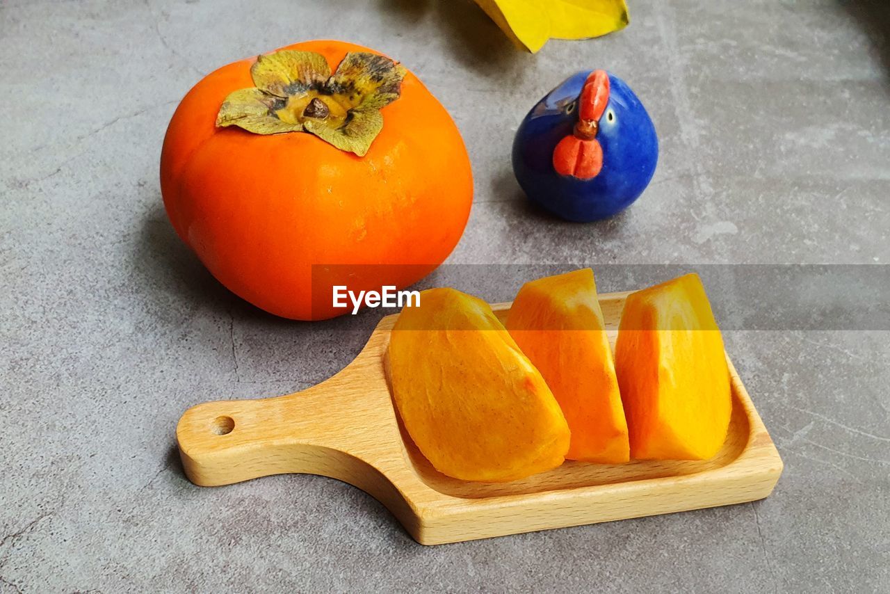 High angle view of cutting persimmon on plate