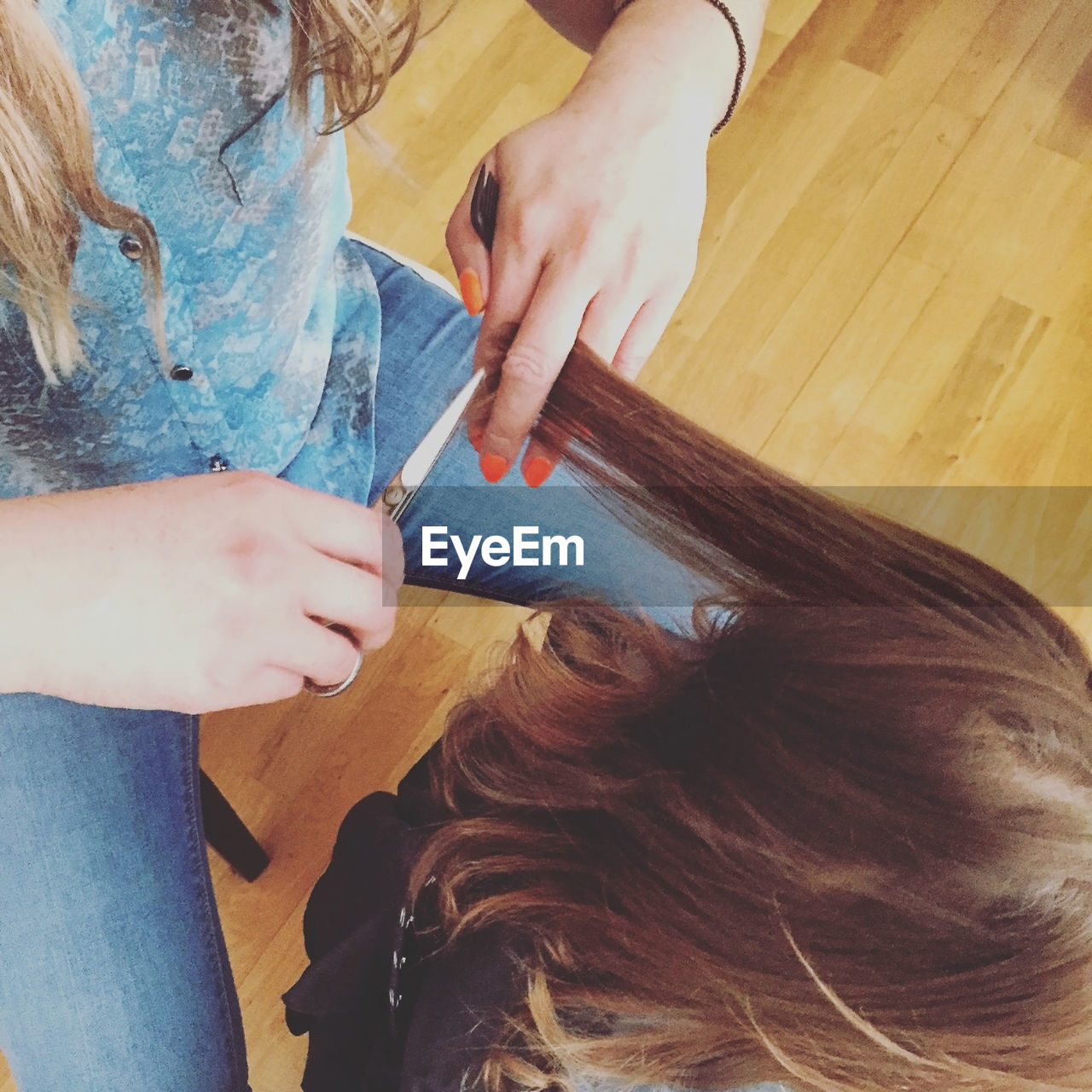 High angle view of hairdresser cutting hair of girl at salon