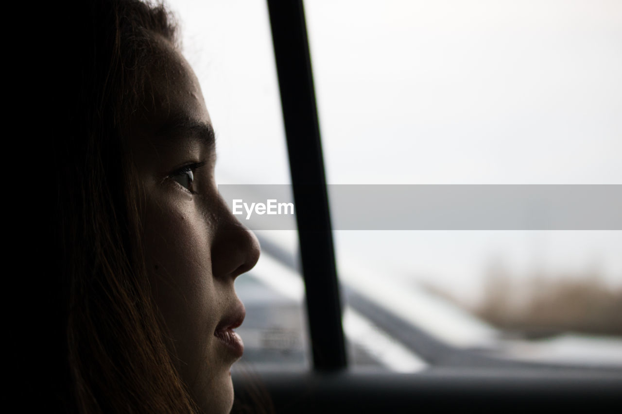 Girl looking through window