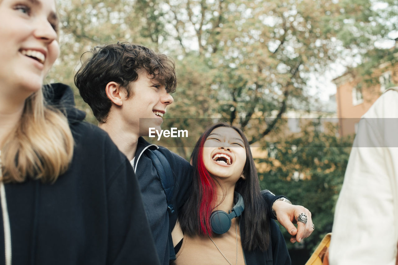 Cheerful male and female teenagers hanging out together