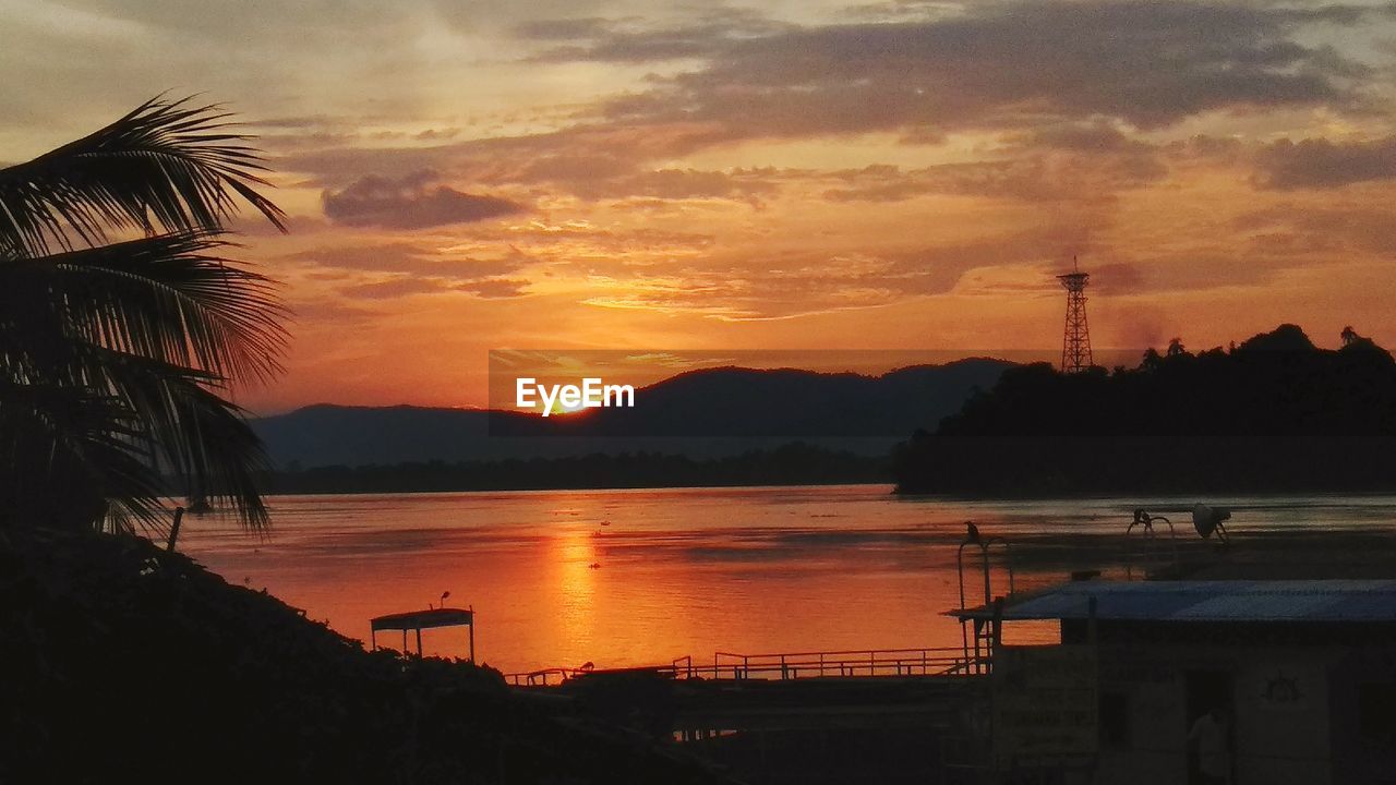 SCENIC VIEW OF LAKE AGAINST SKY AT SUNSET