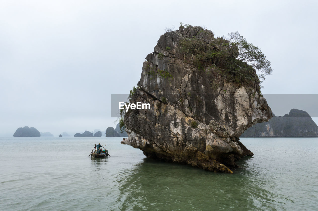 Scenic view of rock formation in sea against sky