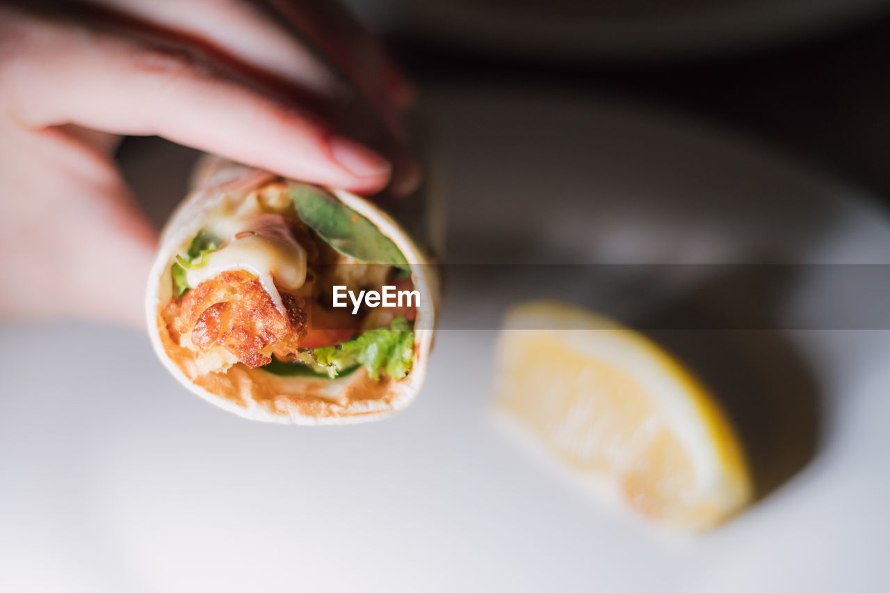 CLOSE-UP OF HAND HOLDING SALAD