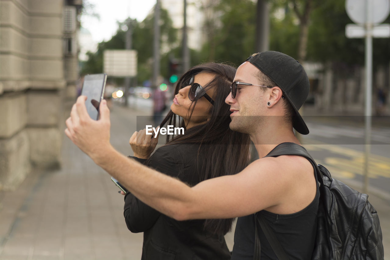 Man taking selfie with friend while standing on road