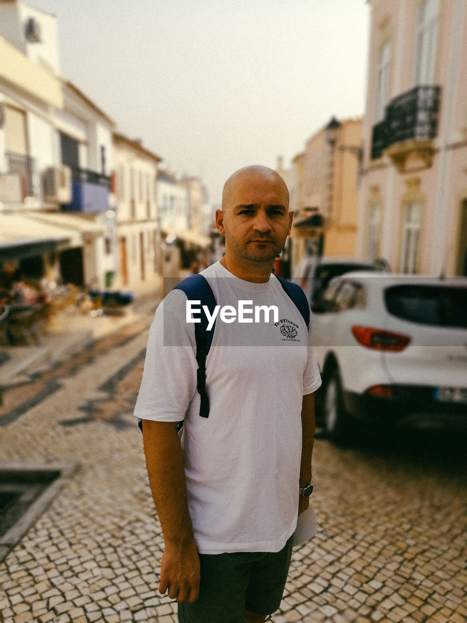 Portrait of bald mid adult man standing in city