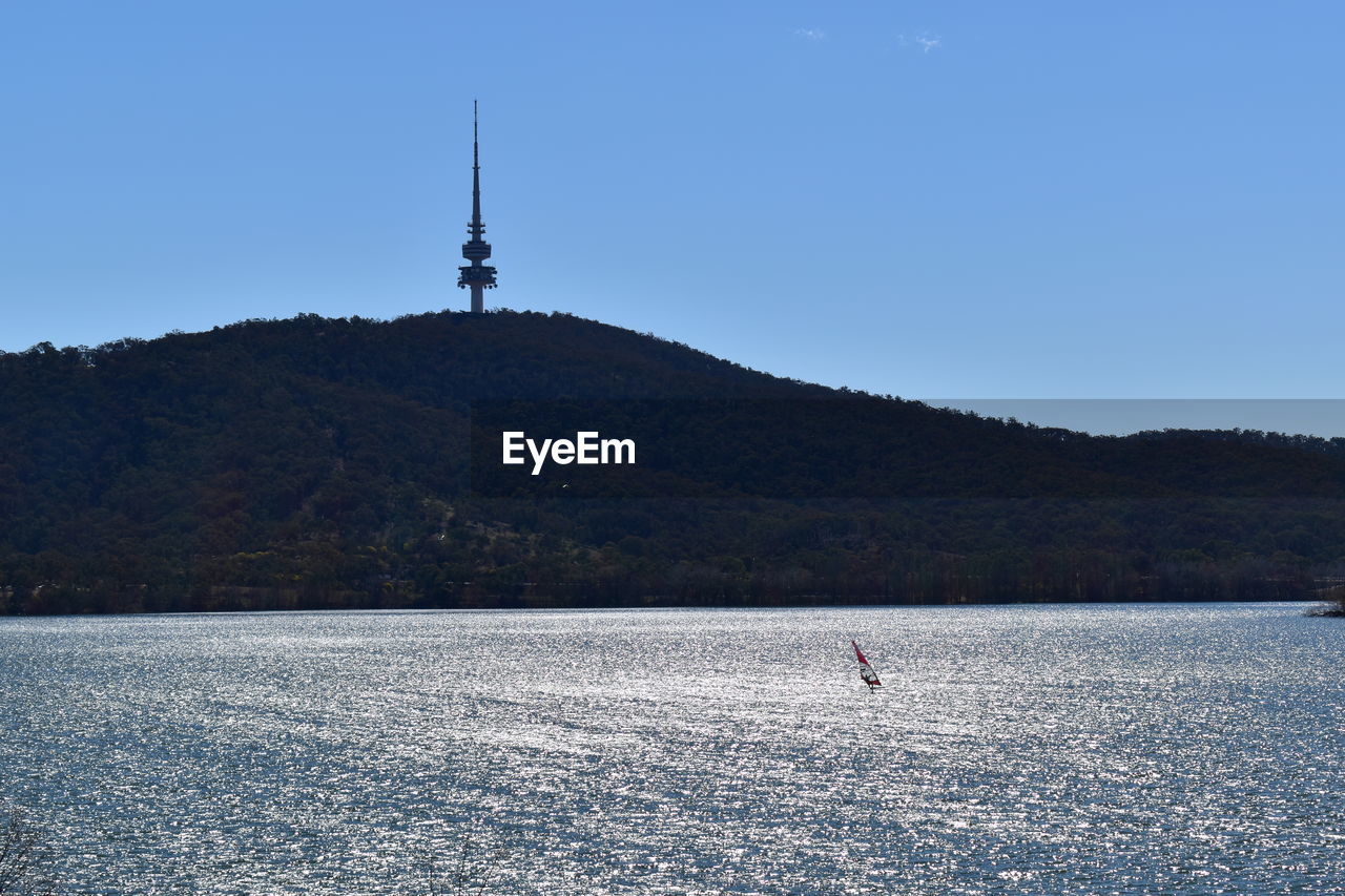 SCENIC VIEW OF LAKE BY MOUNTAIN AGAINST SKY