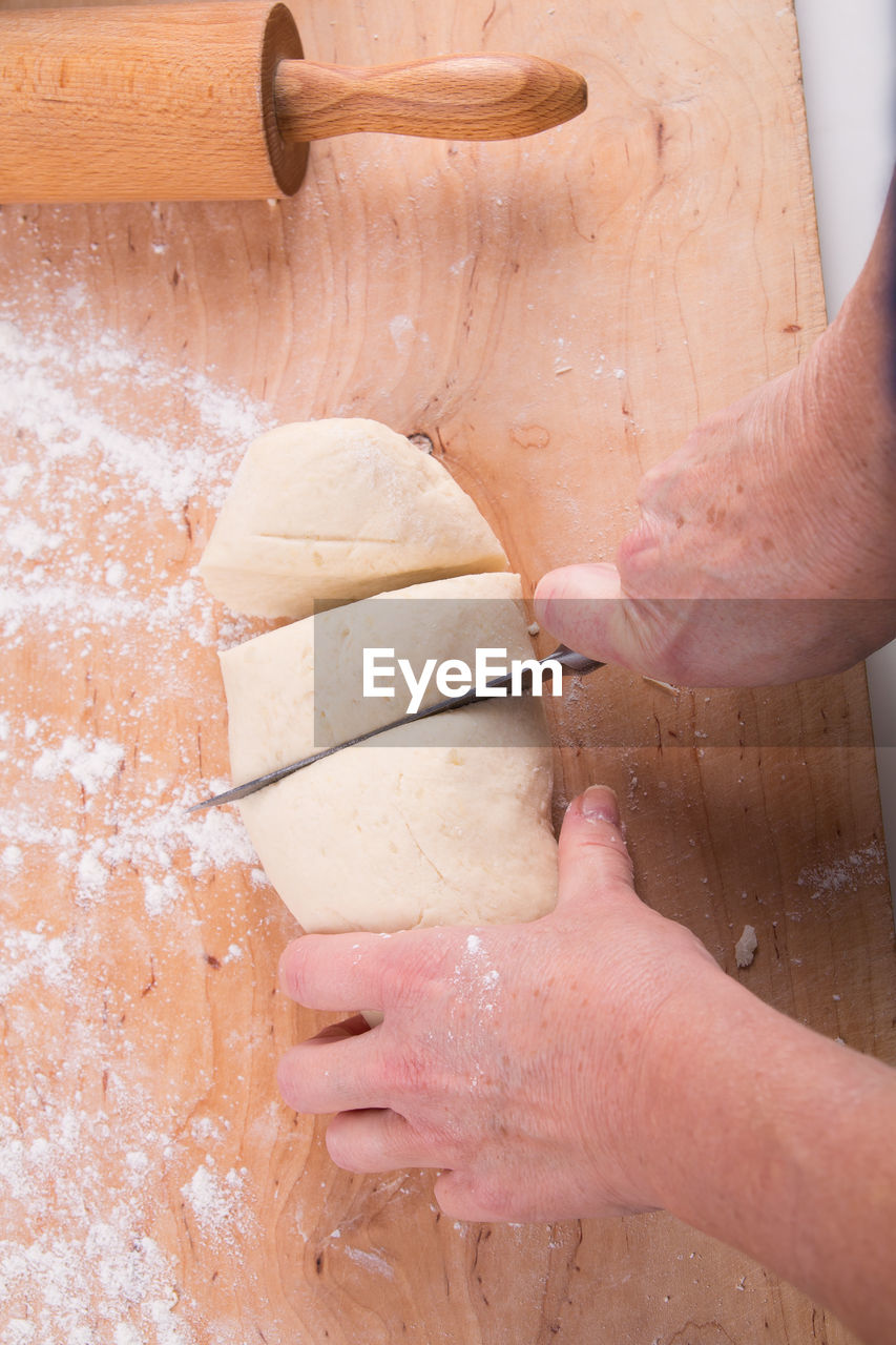 HIGH ANGLE VIEW OF PERSON PREPARING BREAD IN CONTAINER