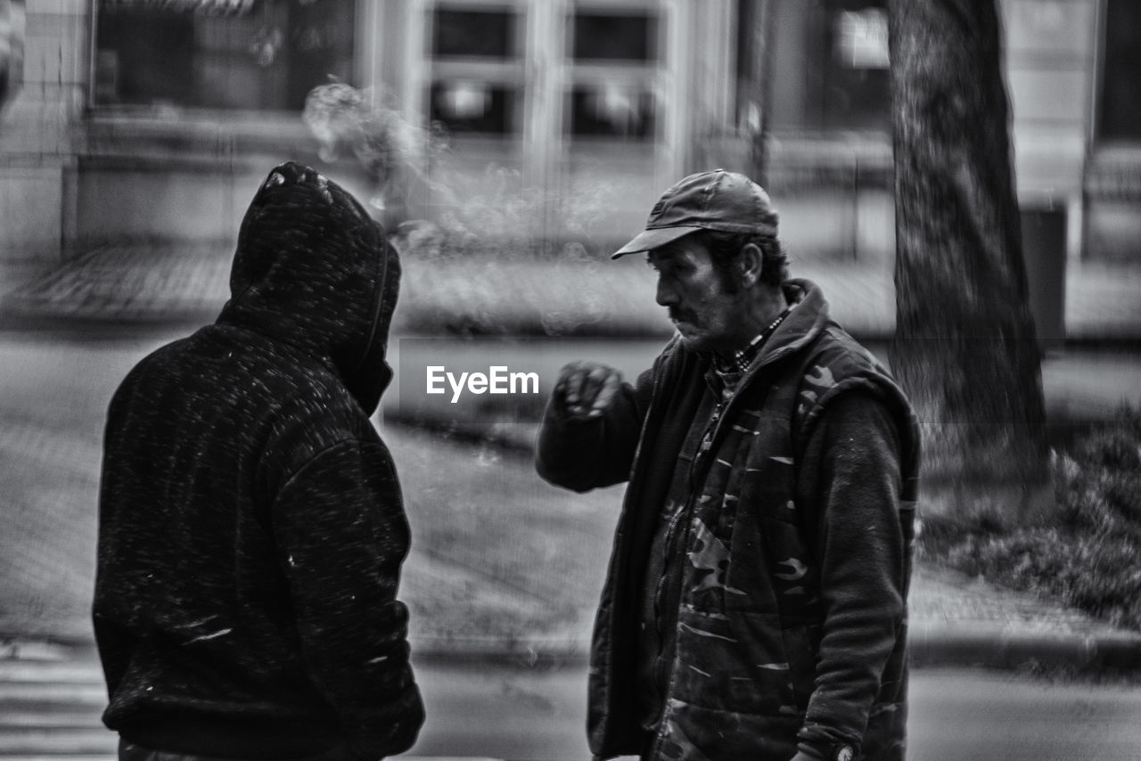 Man standing on wet street in city