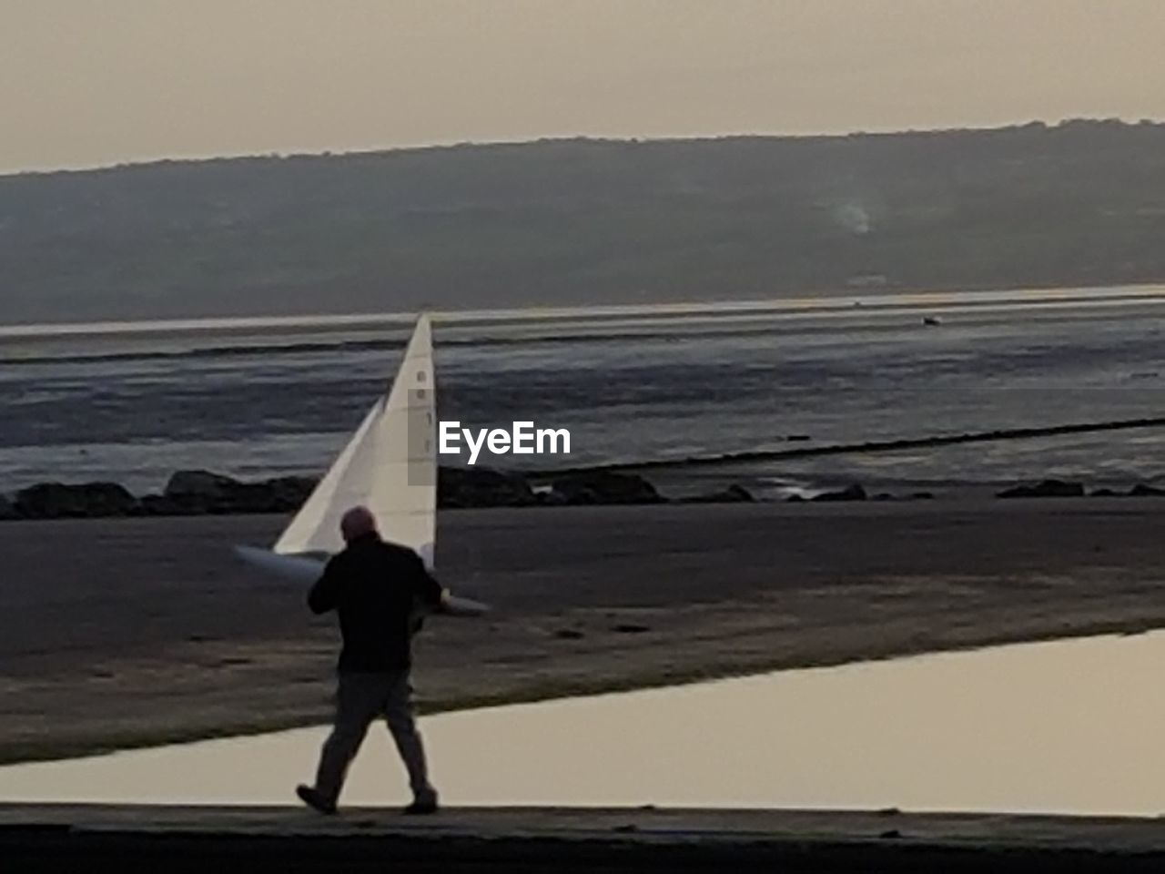 REAR VIEW OF SILHOUETTE MAN STANDING AT BEACH