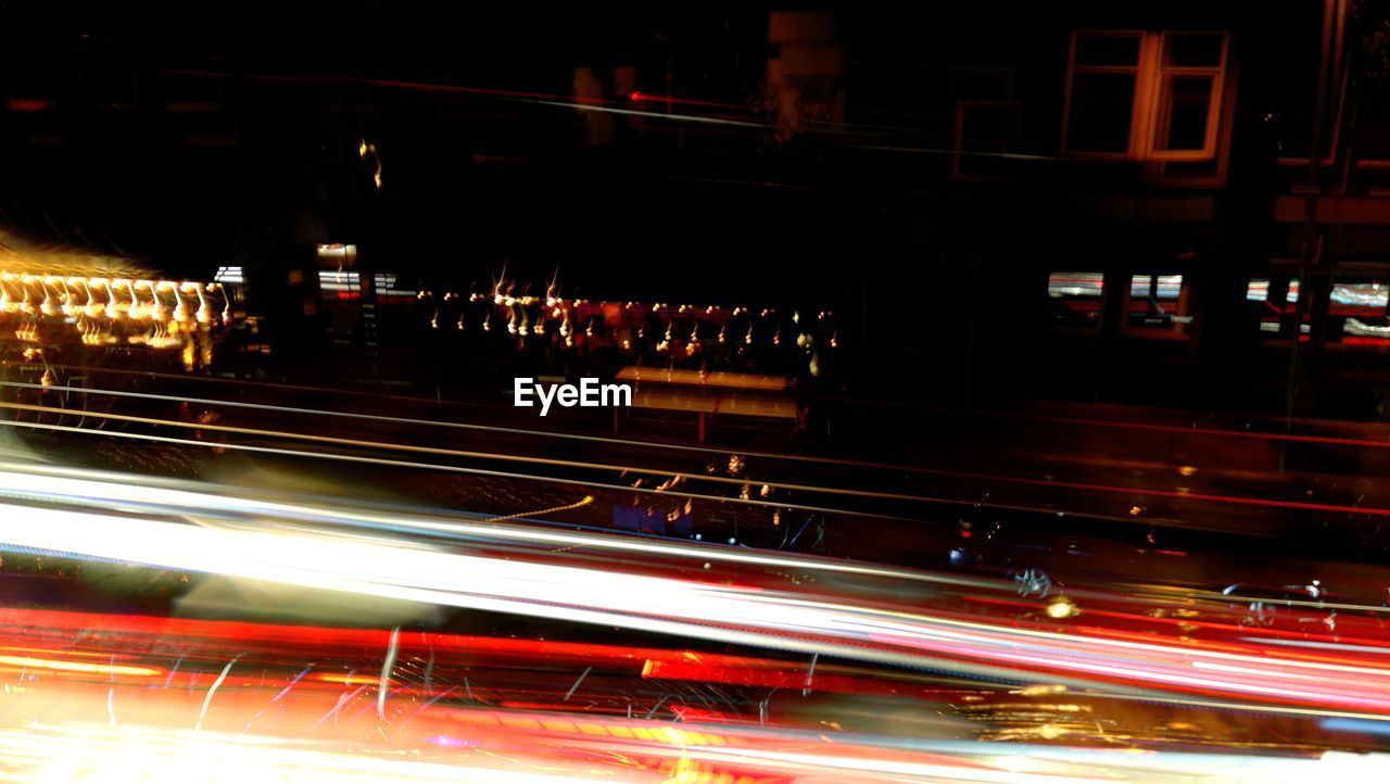 BLURRED MOTION OF LIGHT TRAILS ON CITY STREET AT NIGHT