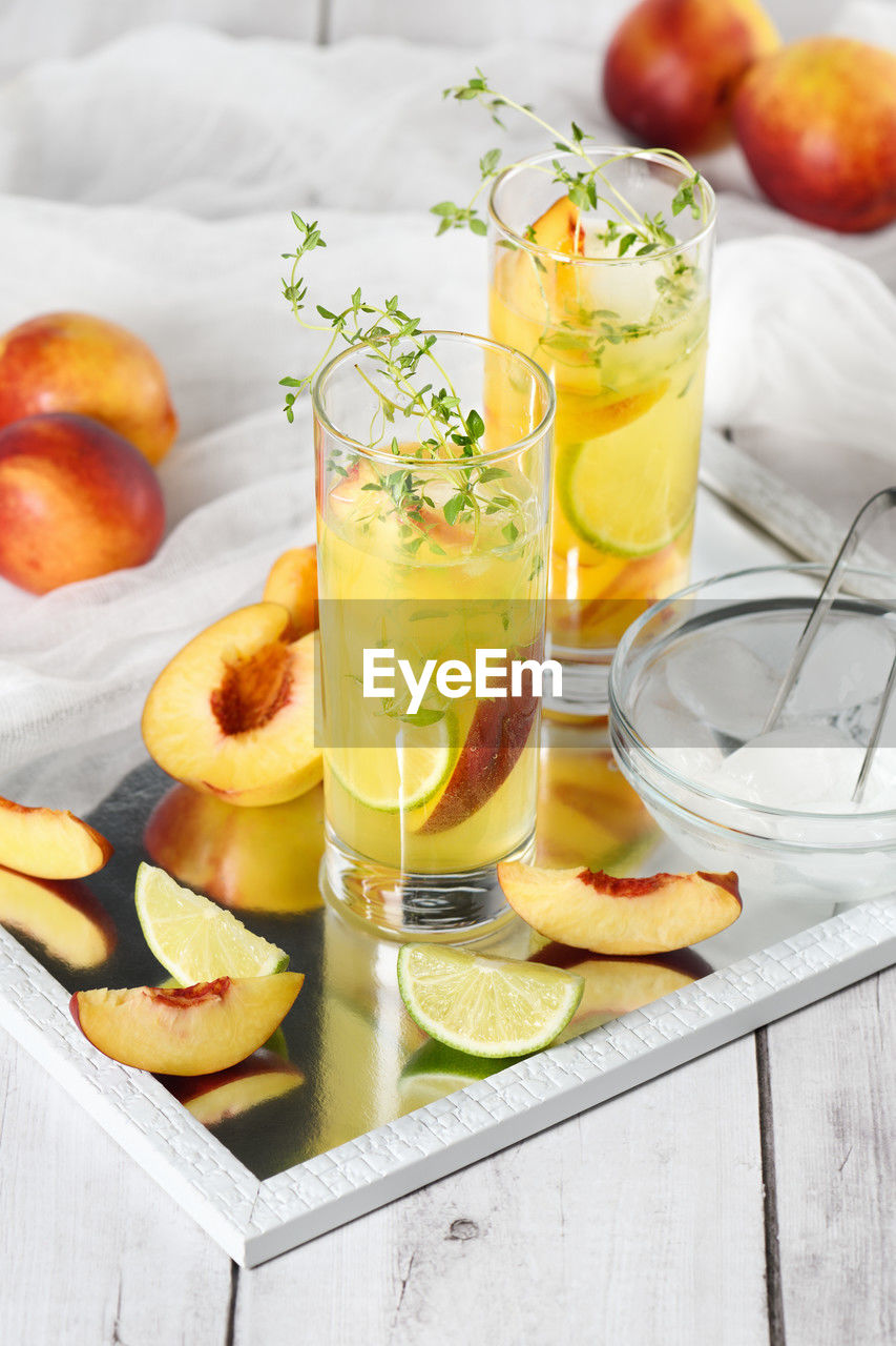 Peach cocktail. refreshing organic non-alcoholic drink, lemonade with ripe nectarine, thyme and lime